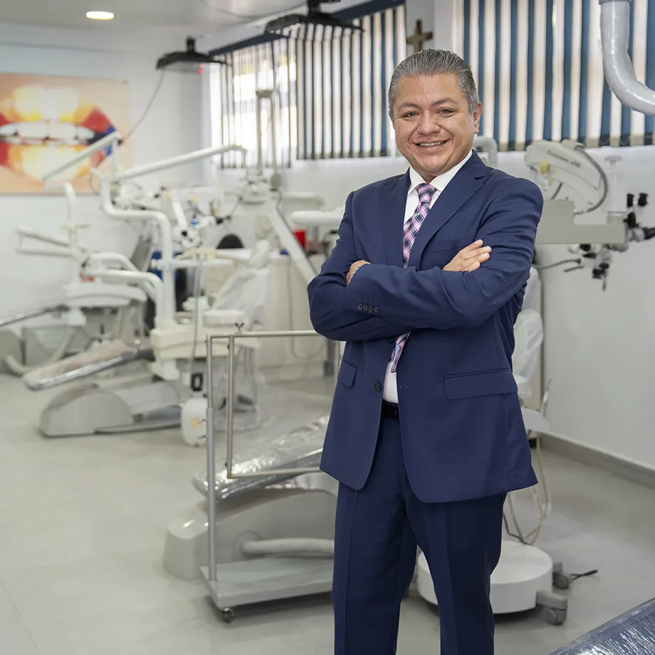 El Dr. Arturo Ramírez Tapia en su consultorio, junto al microscopio dental